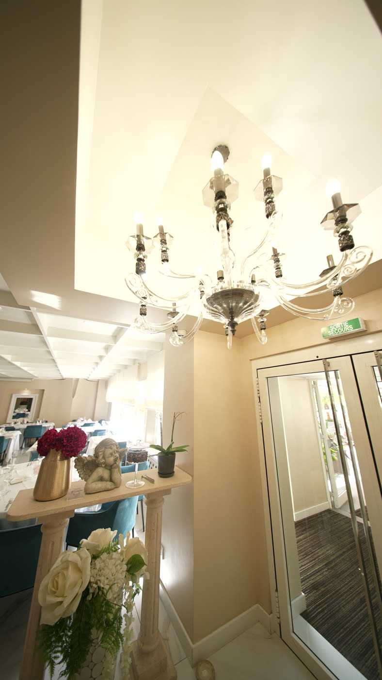 L’entrée du restaurant&nbsp;: lustre en verre, bouquets et fauteuils de velours